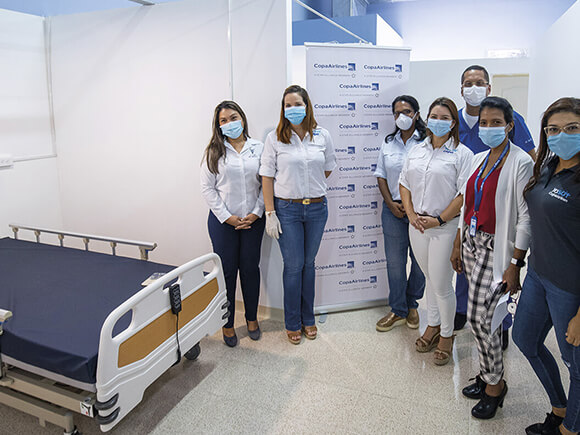 Personal de Copa Airlines entregando una cama como donacion