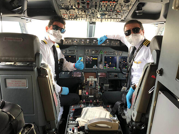 Pilotos en la cabina a punto de llevar un vuelo humanitario